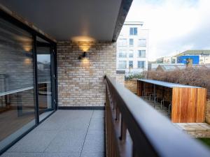 a balcony of a building with a table and chairs at Luxurious Apartments Hackney near Train Station in London