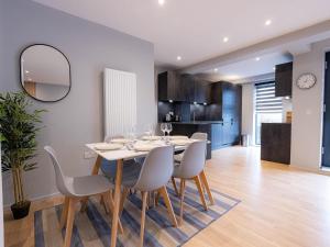 a dining room and kitchen with a table and chairs at Luxurious Apartments Hackney near Train Station in London