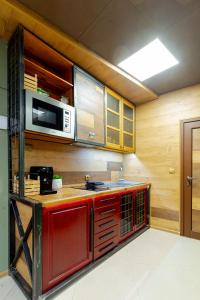 Kuchnia z czerwonymi szafkami i kuchenką mikrofalową w obiekcie Studio77 w mieście Wielkie Tyrnowo