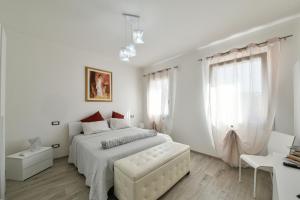 Un dormitorio blanco con una cama blanca y una ventana en I giardini di Lo', en Montagnana