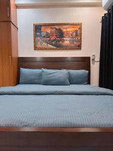 - un lit avec une tête de lit en bois dans une chambre dans l'établissement SR Apartments Islamabad, à Islamabad