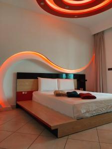 una camera da letto con un letto con una luce arancione sopra di Appartement de Luxe Arena Martil a Martil