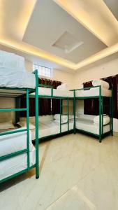 grupa łóżek piętrowych w pokoju w obiekcie Shanti Hostel Rishikesh w mieście Rishikesh