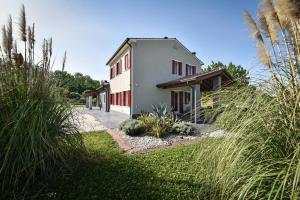 Casa blanca con ventanas rojas y césped en I giardini di Lo', en Montagnana