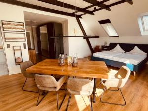 Zimmer mit einem Tisch, Stühlen und einem Bett in der Unterkunft Fährhaus Kirschenland in Jork