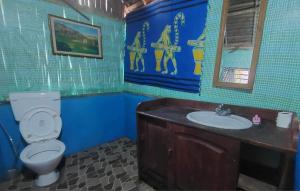 a bathroom with a toilet and a sink at Piscine bimoko in Nosy Be