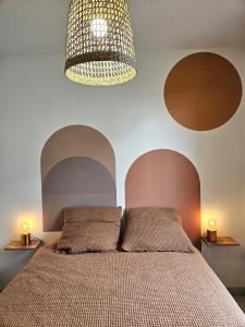 圖盧茲的住宿－Superbe Apt 2 ch, terrasse, WIFI, parking gratuit，一间卧室配有一张带吊灯的床。