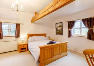 um quarto com uma cama e duas janelas em Cottage at The Butchers Arms em Gloucester