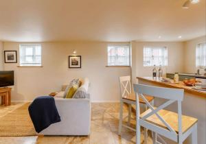 uma sala de estar com um sofá e uma cozinha em Cottage at The Butchers Arms em Gloucester