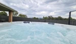 una gran bañera de hidromasaje con agua azul en un patio trasero en Hunter Explorer - Games Room & Spa, en Cessnock