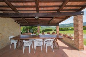 einen Holztisch und Stühle unter einer hölzernen Pergola in der Unterkunft Santa Lina - Lavanda in Pomarance