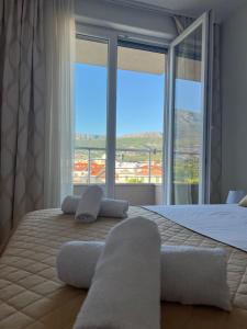 a bedroom with a large bed with a large window at New apartment near Split with garage in Solin