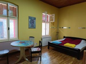 ein Schlafzimmer mit einem Bett und einem kleinen Tisch in der Unterkunft Micro Maxi House in Bela Crkva