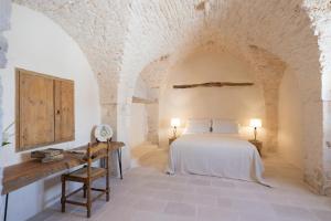 a bedroom with a bed and a table in a room at Masseria Nicola Casavola in Martina Franca