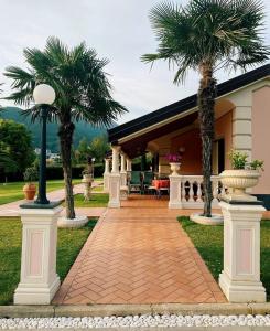 una casa con dos palmeras y una pasarela en B&B Terra Di Liguria, en Casarza Ligure
