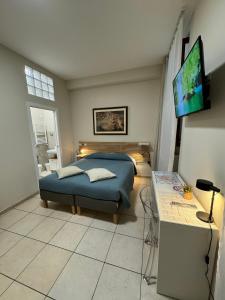 a bedroom with a bed and a table and a television at affittacamere Folignocentro in Foligno