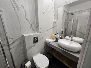 La salle de bains est pourvue d'un lavabo, de toilettes et d'un miroir. dans l'établissement Sun Sea Center, à Eilat