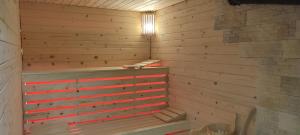 eine Sauna mit einer Holzwand und einer Badewanne in der Unterkunft Agroturystyka Oblica in Zawoja