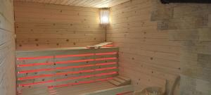 a sauna with a wooden wall and a tub at Agroturystyka Oblica in Zawoja