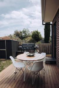 a patio with a table and chairs on a deck at MODERN LUXE TOWNHOUSE / ROSEBUD in Rosebud