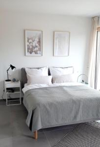 a white bedroom with a large bed with white pillows at Bude 23 - Ferienwohnung Aalen in Aalen