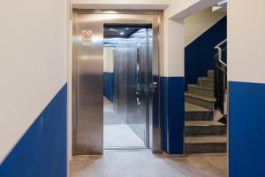MYKY Hotel Boardinghouse في هامبورغ: مصعد في مبنى به جدران زرقاء وسلالم