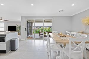 a kitchen and dining room with a table and chairs at Pineapple House - Furry Friends Welcome! in Cessnock
