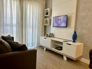 a living room with a tv on a wall at Apto 28A - Residencial Palladium Centro, Penha SC in Penha