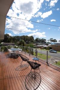 a deck with two chairs and a table on it at OCEANVIEWS BEACH HOUSE / BATEHAVEN in Batehaven