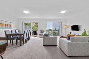 a living room with a couch and a dining room at Bay Bliss - Coastal Villa in Nelson Bay