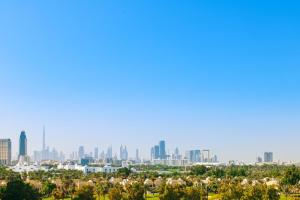 Blick auf die Skyline der Stadt von einem Park in der Unterkunft Le Meridien Fairway in Dubai