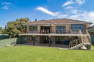 a house with a large yard in front of it at WATERFRONT HOME WITH POOL / SHELLHARBOUR in Shellharbour