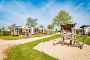 een rij lodges op een onverharde weg bij Vakantiepark Eiland van Maurik in Maurik