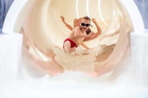 a man in sunglasses is in the water on an inflatable at Vakantiepark Eiland van Maurik in Maurik