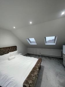 um quarto com uma cama grande e clarabóias em Studio Flat near wembley arena em Wealdstone