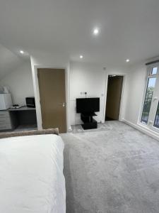 a bedroom with a bed and a flat screen tv at Studio Flat near wembley arena in Wealdstone