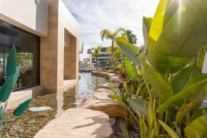 a house with a water feature next to a canal at Apartment AMAZING in Orihuela