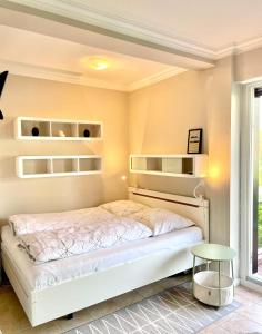 um quarto com uma cama branca e prateleiras em Bellevue 16 KaMare - direkte Strandlage em Scharbeutz