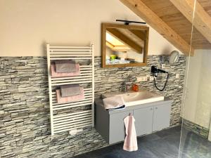 ein Badezimmer mit einem Waschbecken und einer Steinmauer in der Unterkunft Bergbauernhof Wechs in Ofterschwang