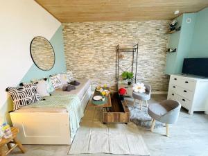 een slaapkamer met een bed, een stoel en een televisie bij Le MINTY Cocoon, bright & close to Paris in Maisons-Laffitte