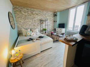 een slaapkamer met een groot bed en een bakstenen muur bij Le MINTY Cocoon, bright & close to Paris in Maisons-Laffitte
