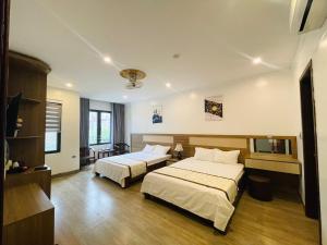 pokój hotelowy z 2 łóżkami i telewizorem w obiekcie Thien Hai Hotel w mieście Sam Son