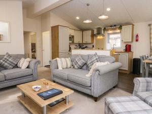 a living room with two couches and a table at Lakeland Dream South Lakeland Leisure Lodge in Carnforth