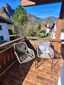 duas cadeiras numa varanda com montanhas ao fundo em Apartment Bergliebe em Oberammergau