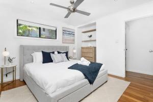 a bedroom with a large bed with a ceiling fan at Sea Haven - Furry Friends Welcome! in Lemon Tree Passage