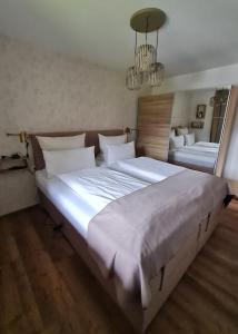 een grote slaapkamer met 2 bedden en een spiegel bij Apartment Bergliebe in Oberammergau