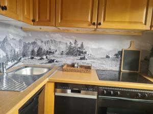 a kitchen with a mountain mural on the wall at Apartment Bergliebe in Oberammergau