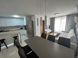 a kitchen and a living room with a table and chairs at New apartment near Split with garage in Solin