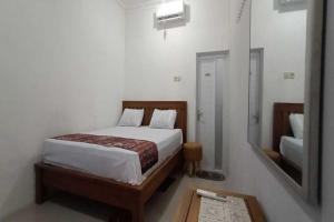een slaapkamer met een bed en een spiegel bij OYO 93963 Homestay Kita Purworejo in Purworejo