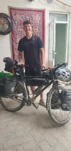 un hombre está de pie junto a una bicicleta en Guest house IBROHIM حلال, en Bukhara
